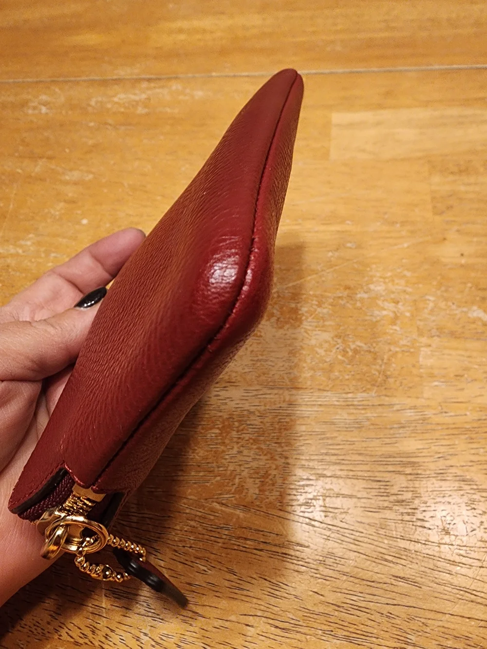 red polished pebble leather Coach wristlet, featuring gold-tone hardware